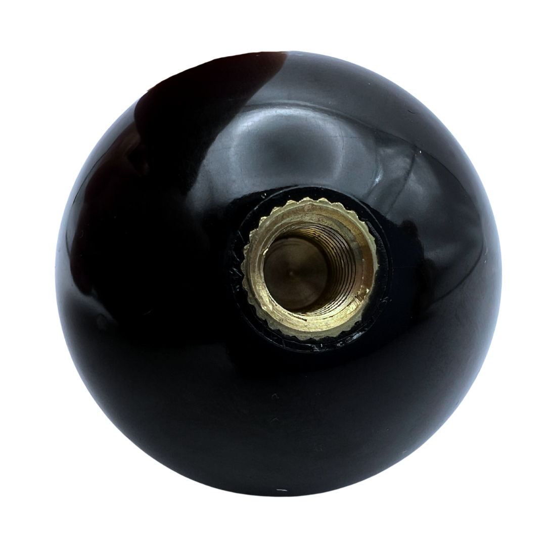 Black spherical joystick knob with brass screw in center on a white background