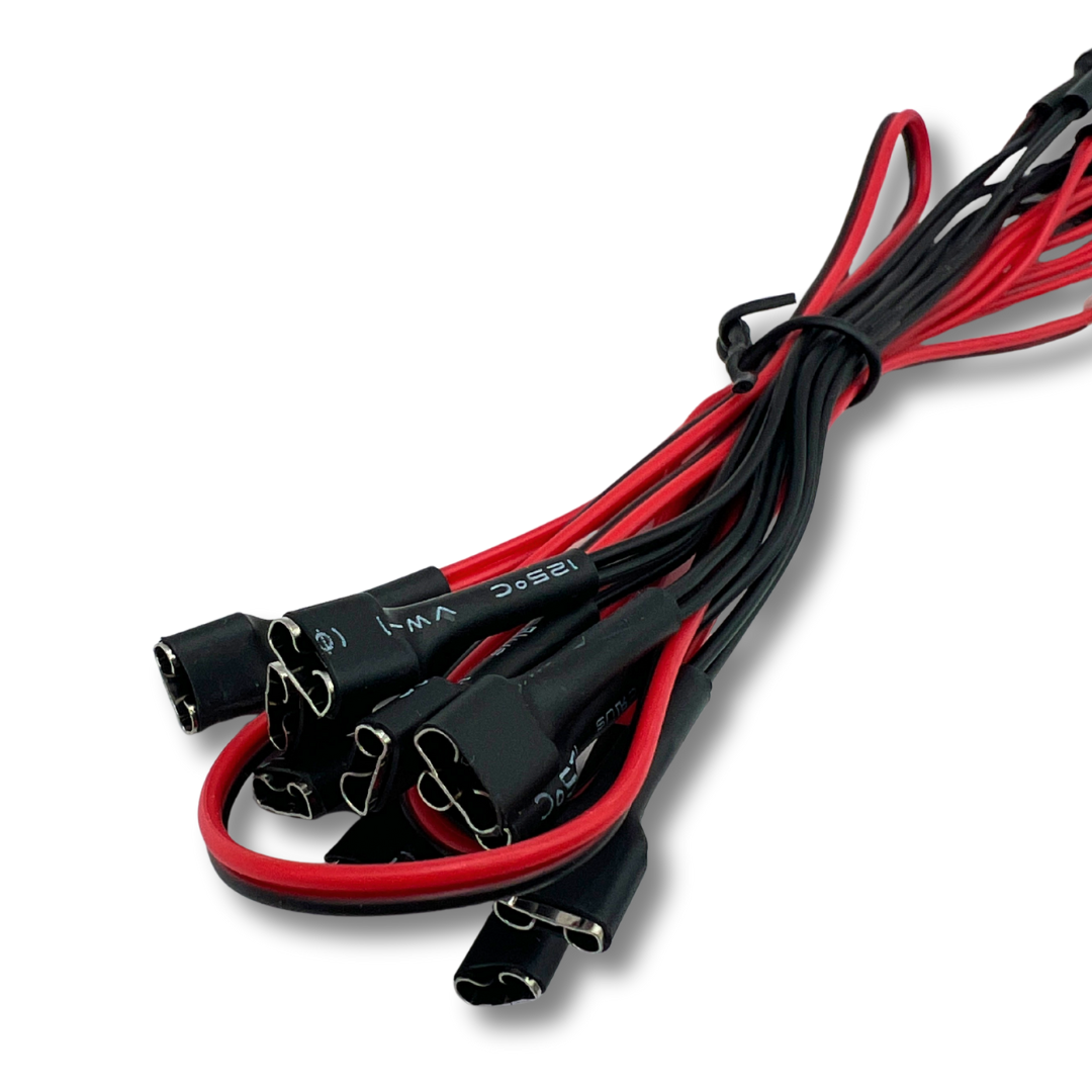 Close-up of LED daisy chain harness connectors for arcade encoder kits — red and black wires with quick-connect ends.