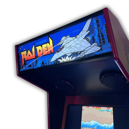 Raiden arcade marquee close up angle view on a DIY arcade cabinet showing the bold orange Raiden logo and fighter jet artwork with the Raiden high score screen visible below.