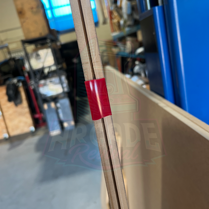 Red T-moulding inserted into a routed slot on MDF arcade cabinet side panel showing precise fit