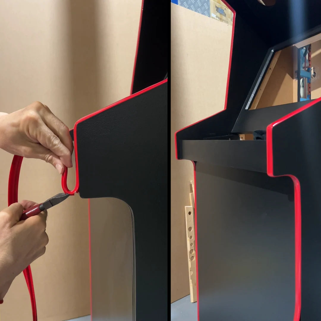 Installing red T-moulding on a DIY arcade machine cabinet for a professional arcade finish