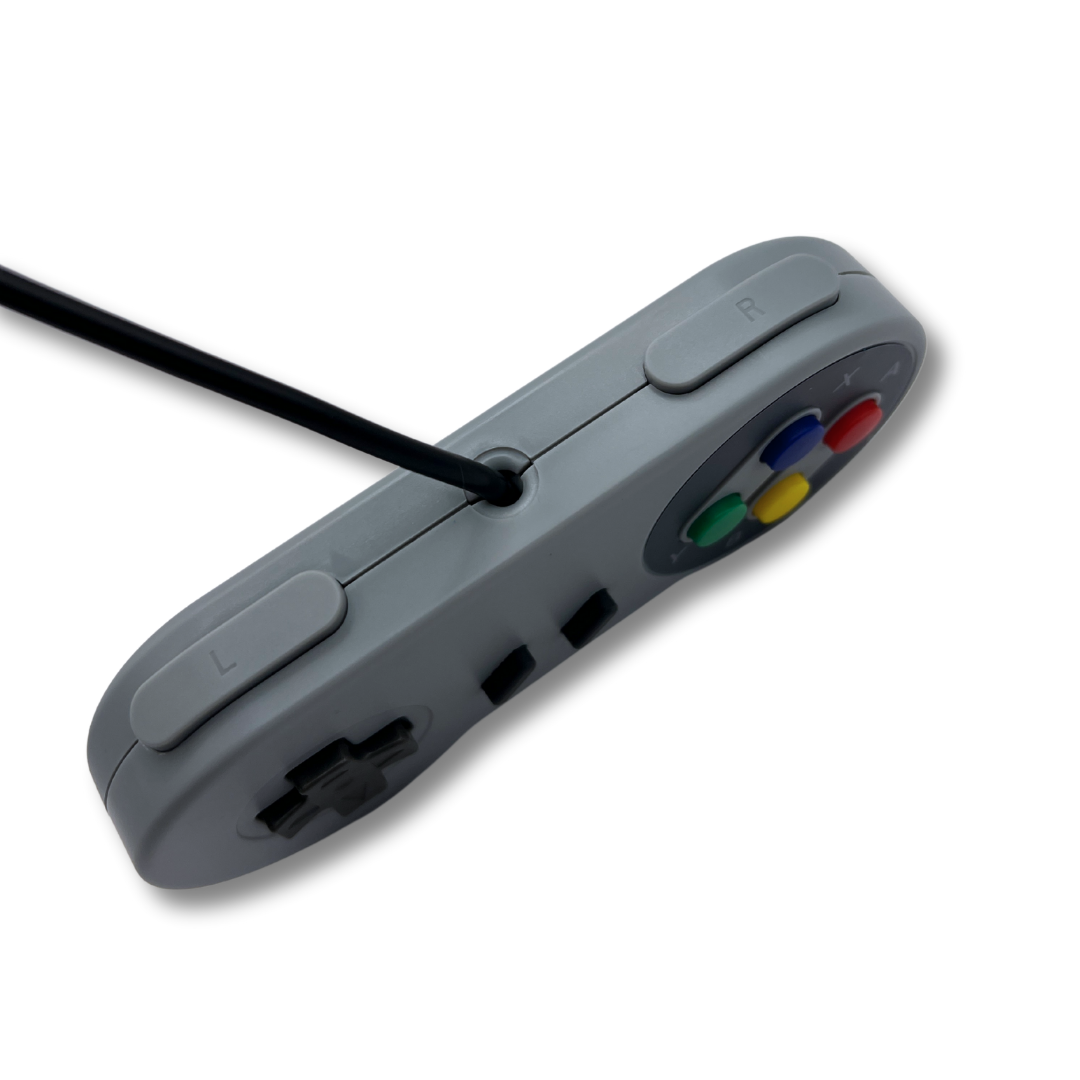 Top-down close-up of SNES-style USB controller showing shoulder L/R buttons and cable insertion for retro gaming setup.